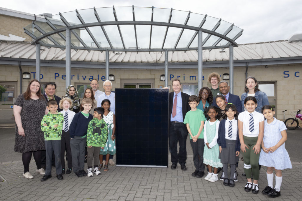 Students and staff with a solar panel outside Perivale School, Ealing, West London